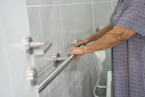 asiatico anziano o anziana signora anziana paziente uso toilette bagno maniglia sicurezza nel reparto ospedaliero infermieristico, sano forte concetto medico. foto