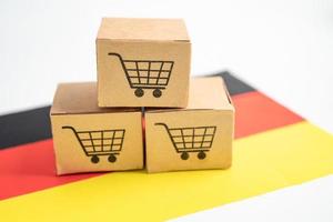 scatola con logo del carrello della spesa e bandiera della germania, import export shopping online o e-commerce finanza servizio di consegna negozio spedizione del prodotto, commercio, concetto di fornitore. foto