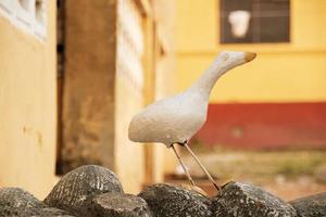 statua di una colomba bianca davanti a una casa foto