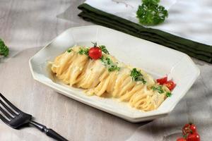 cena di pasta con capelli d'angelo alfredo con salsa bianca cremosa, parmigiano ed erbe aromatiche foto