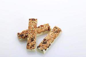 snack salutare, una barretta a base di cereali e noci con miele e cioccolato bianco. foto