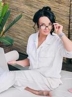 la bella donna imprenditrice freelance con gli occhiali lavora in remoto. istruzione, viaggi, concetto di business foto
