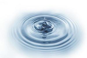 spruzzi d'acqua, acqua che gocciola sulla superficie dell'acqua onda d'acqua blu isolata su sfondo bianco foto