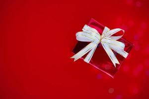 confezione regalo con un nastro bianco su sfondo rosso vista ravvicinata di un prodotto ad alta risoluzione. foto