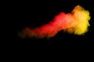 esplosione di polvere di colore arancione su sfondo nero. foto