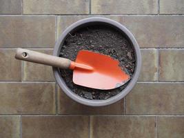 vanga da giardino e secchio di terra per piante in vaso foto