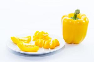 ingrediente giallo affettato del peperoncino rosso della campana sul piatto bianco