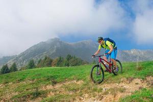 un giovane maschio in sella a una mountain bike all'aperto foto