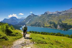 pedalare in montagna passando per un lago foto