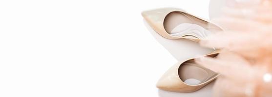 scarpe classiche eleganti con tacco beige e abito festoso in tulle su sfondo bianco. striscione. concetto dopo la festa. celebrazione del vincitore della donna. foto