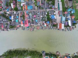 vista aerea vista dall'alto del villaggio di pescatori con barche da pesca e tetto di casa al molo di suratthani thailandia. vista panoramica dall'alto foto