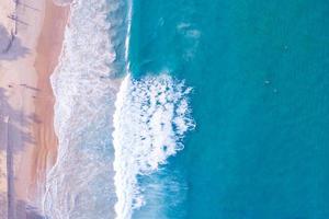 vista aerea spiaggia sabbiosa e onde bellissimo mare tropicale al mattino stagione estiva immagine da vista aerea ripresa del drone, vista dall'alto dall'alto onde del mare foto