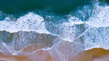 vista aerea spiaggia sabbiosa e onde bellissimo mare tropicale al mattino stagione estiva immagine da vista aerea ripresa del drone, vista dall'alto dall'alto onde del mare foto