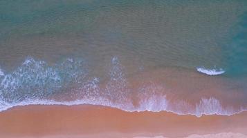 vista aerea del mare e della spiaggia di sabbia al tramonto o all'alba incredibile onda che si infrange sulla riva sabbiosa spiaggia di sabbia rosa bella per le vacanze estate sfondo tropicale immagine della destinazione dalla fotocamera del drone. foto