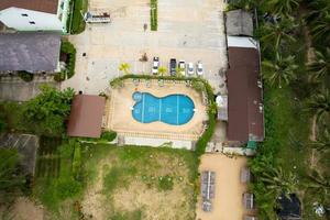 piscina vista dall'alto con acqua blu vista aerea resort e parcheggio all'aperto foto