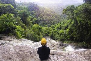 donna seduta in cascata.giovane rilassante in cascata.buona sana,pacifica.foto concetto di viaggio e stile di vita. foto