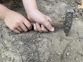 un martello nelle mani di un bambino foto