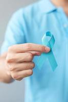 novembre mese di sensibilizzazione sul cancro alla prostata, uomo in camicia blu con mano che tiene un nastro blu per sostenere le persone che vivono e le malattie. concetto di salute, uomini internazionali, padre e giornata mondiale del cancro foto