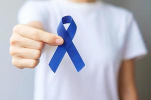 marzo mese di sensibilizzazione sul cancro colorettale, donna che tiene un nastro blu scuro per sostenere le persone che vivono e le malattie. concetto di assistenza sanitaria, speranza e giornata mondiale del cancro foto