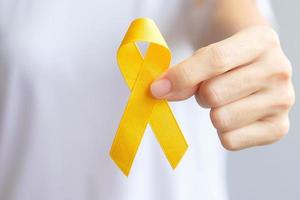 giornata di prevenzione del suicidio, sarcoma, mese di sensibilizzazione sul cancro alle ossa, alla vescica e all'infanzia, nastro giallo per sostenere le persone che vivono e le malattie. concetto di assistenza sanitaria per bambini e giornata mondiale del cancro foto