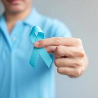 novembre mese di sensibilizzazione sul cancro alla prostata, uomo in camicia blu con mano che tiene un nastro blu per sostenere le persone che vivono e le malattie. concetto di salute, uomini internazionali, padre e giornata mondiale del cancro foto