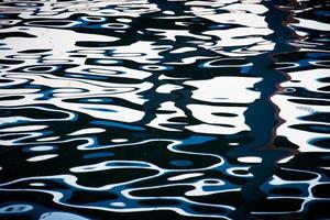 superficie dell'acqua con riflessi di luce scintillante foto