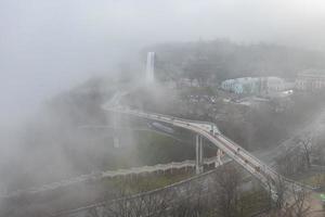 vista aerea in una giornata nebbiosa sull'arco dell'amicizia della gente e sul ponte parkovy, kiev, ucraina foto