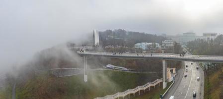 vista aerea in una giornata nebbiosa sull'arco dell'amicizia della gente e sul ponte parkovy, kiev, ucraina foto