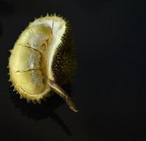 durian tagliato a metà su sfondo nero. foto