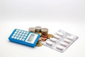 monete in baht tailandese, set di capsule per farmaci e calcolatrice blu foto