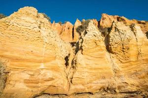 Pilastri di pietra di sabbia sulla spiaggia di roccia nera nel sobborgo di sandringham di melbourne, australia. foto