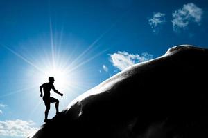 sagoma di un uomo che corre su per la collina fino alla cima della montagna. trekking, foto