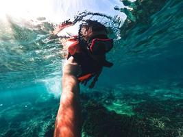 snorkeling in mare su un'isola tropicale foto