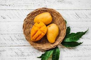 frutto di mango, mango giallo fresco su legno bianco foto