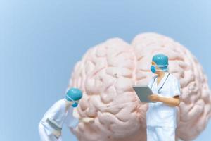 chirurgo di persone in miniatura che analizza il cervello del paziente foto