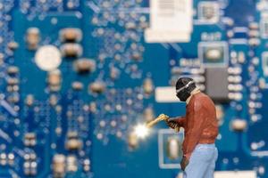 i tecnici di riparazione di computer di persone in miniatura riparano una scheda elettronica con il gas foto