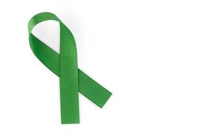 nastro verde, simbolo di consapevolezza sociale, isolato su sfondo bianco, vista dall'alto. giornata mondiale contro il cancro. copia spazio. foto