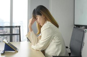 giovane donna d'affari stressata e stanca in un ufficio moderno foto