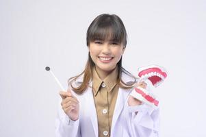 giovane dentista femminile sorridente su sfondo bianco studio foto