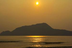 la sera soffiano vento forte e onde oceaniche. il fondale è giallo chiaro, caldo, alternato a vedere le isole nel mare create dalla natura, belle e romantiche. foto