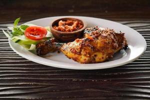 pollo arrosto al miele estetico con verdure, menu di cucina asiatica balinese e cibo indonesiano su fondo di legno