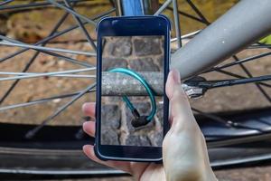 rapina in bicicletta che compone una mano femminile che tiene uno smartphone che scatta una foto. foto