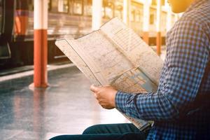 uomo asiatico che guarda la mappa con la ricerca della posizione per il viaggio. foto