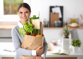giovane donna con la borsa della spesa con le verdure in piedi foto