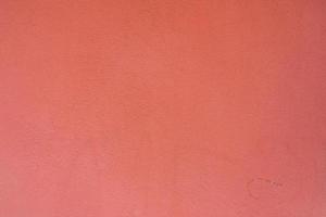 sfondo da un motivo di muro di pietra rosa ricoperto di intonaco decorativo. foto