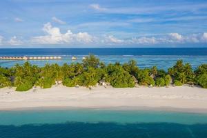 paradiso delle maldive panoramico. paesaggio aereo tropicale, giungla di palme con vista sul mare, ville sull'acqua in lontananza mare fantastico, spiaggia lagunare, natura tropicale. banner di destinazione turistica esotica, vacanze estive