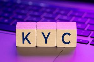 kyc parola su blocchi di legno sul computer portatile con luci colorate. online conosci il tuo concetto di cliente foto