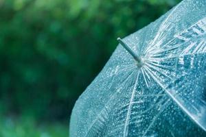 le gocce di pioggia si aggrappano all'ombrello trasparente per proteggere la stagione delle piogge in toni vintage. focalizzazione morbida. effetto di messa a fuoco superficiale. foto
