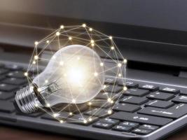 laptop e lampadina incandescente. conoscenza di autoapprendimento o istruzione e concetto di studio aziendale. idea di apprendimento online o e-learning da casa foto