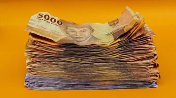 cartamoneta della rupia indonesiana. concetto di finanza, affari e successo. risparmiando i tuoi soldi. uang 10000 5000 rupie indonesia. sfondo arancione isolato. foto